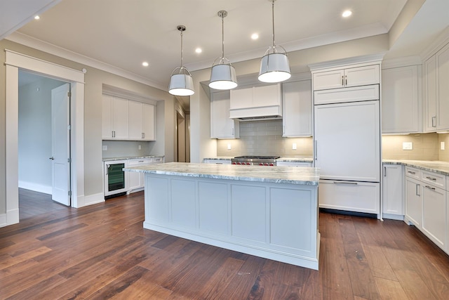 kitchen featuring beverage cooler, paneled fridge, light stone countertops, pendant lighting, and white cabinetry