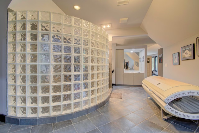 bathroom with tile patterned flooring, vanity, and vaulted ceiling