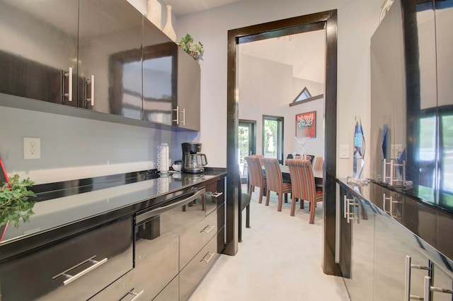 kitchen with a towering ceiling and light carpet