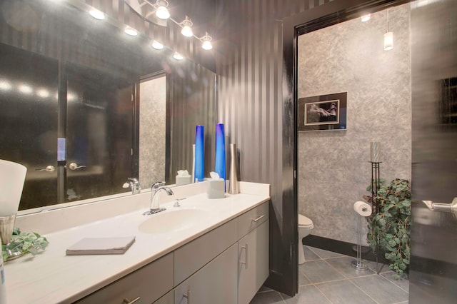 bathroom with toilet, vanity, and tile patterned floors