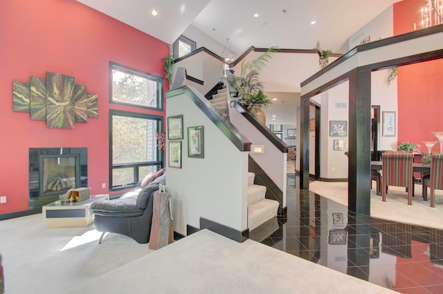 stairs with a wealth of natural light, tile patterned floors, and a high ceiling