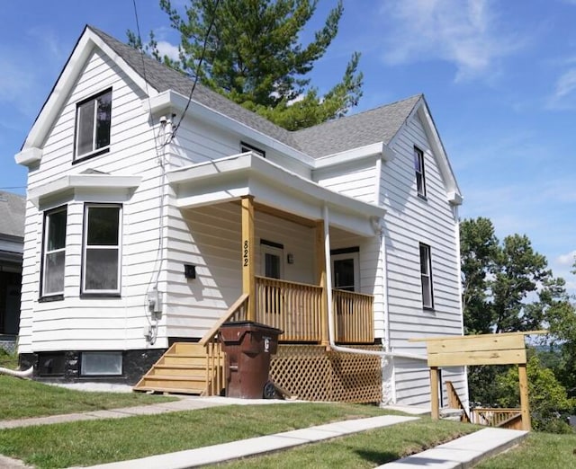 view of front facade featuring a front yard and covered porch