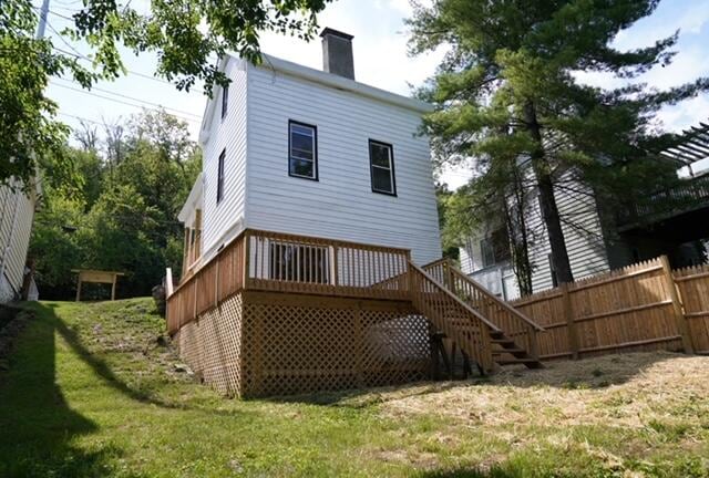 back of house featuring a wooden deck and a lawn