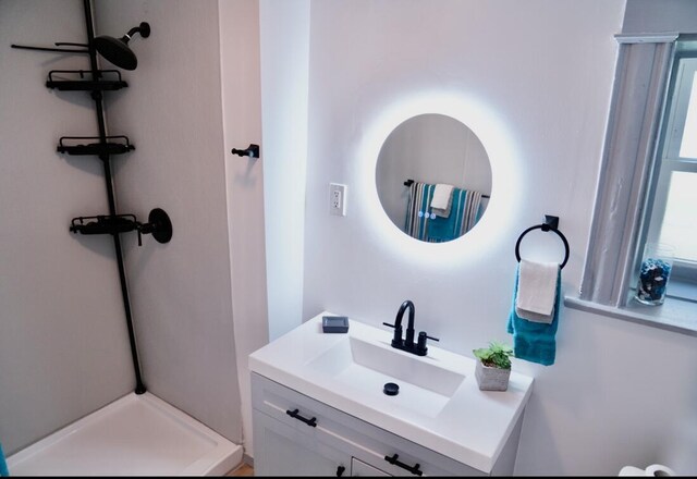 bathroom with vanity and a shower