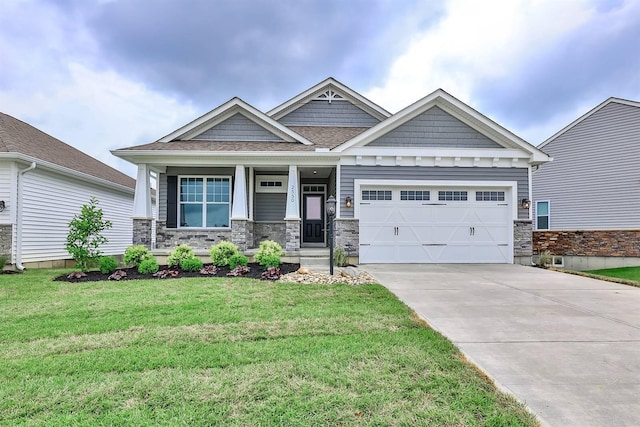 craftsman house featuring a porch, a garage, and a front lawn