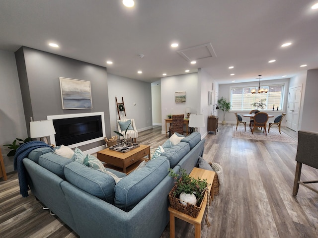 living room featuring recessed lighting, baseboards, wood finished floors, and a glass covered fireplace