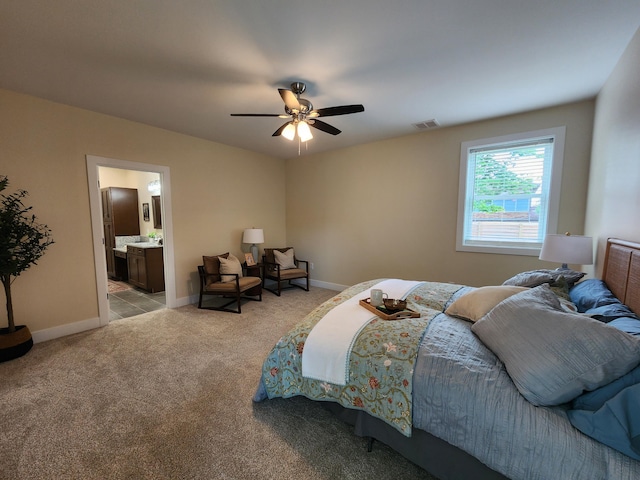 bedroom featuring ensuite bathroom, light carpet, a ceiling fan, visible vents, and baseboards