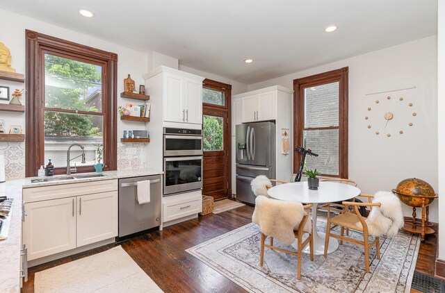 kitchen featuring sink, white cabinetry, dark hardwood / wood-style floors, and stainless steel appliances