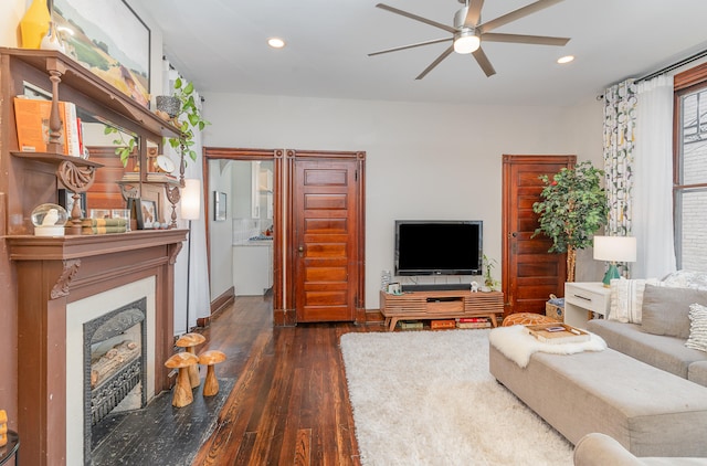 living room featuring ceiling fan and dark wood-type flooring