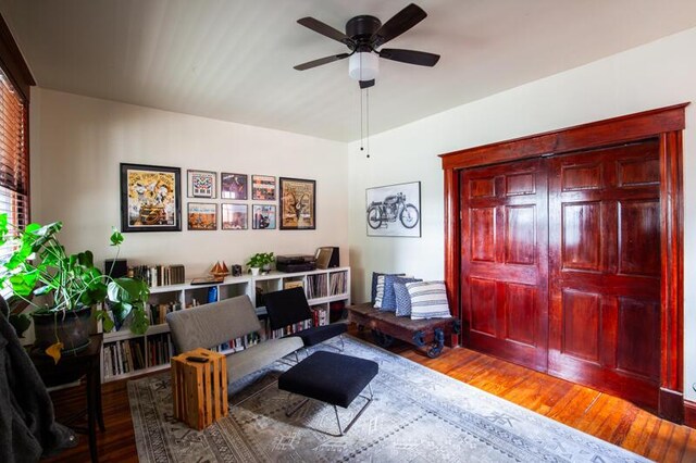 living area featuring wood-type flooring and ceiling fan