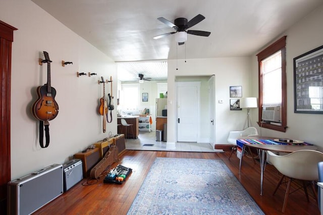 interior space with a ceiling fan, a wealth of natural light, cooling unit, and wood finished floors