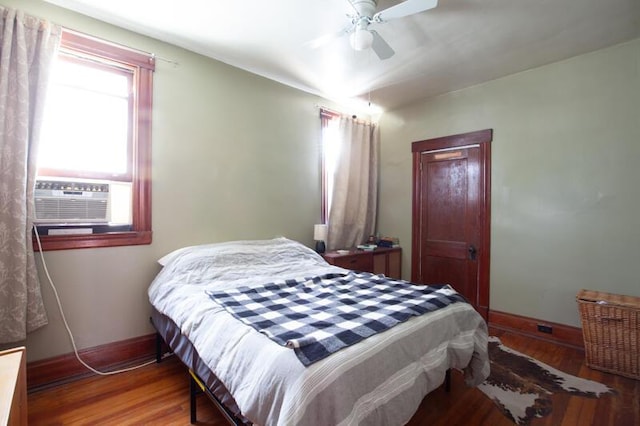 bedroom with ceiling fan, baseboards, cooling unit, and wood finished floors