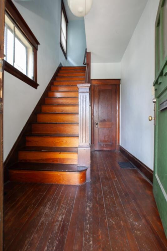 stairs featuring wood-type flooring and baseboards