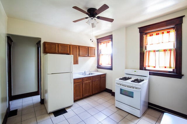 kitchen with sink, light tile patterned floors, ceiling fan, and white appliances