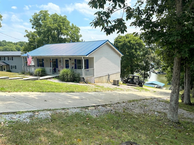 view of front of home featuring a porch, central AC unit, and a front lawn