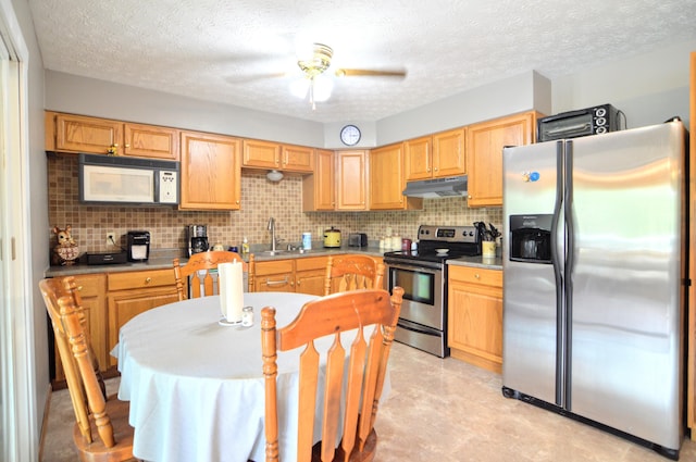 kitchen with sink, backsplash, ceiling fan, stainless steel appliances, and a textured ceiling