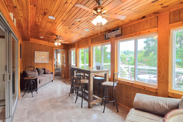 sunroom / solarium with wood ceiling, ceiling fan, and a healthy amount of sunlight