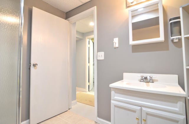 bathroom with tile patterned flooring, vanity, and a shower with door