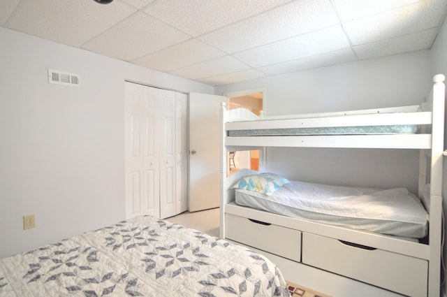 bedroom with a paneled ceiling and a closet