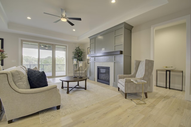 828 Fairbanks Ln, Southgate, KY 41071 - living room with ceiling fan, a glass covered fireplace, light wood finished floors, and a raised ceiling