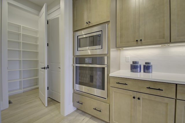 828 Fairbanks Ln, Southgate, KY 41071 - kitchen featuring backsplash, light countertops, appliances with stainless steel finishes, and light wood-style floors