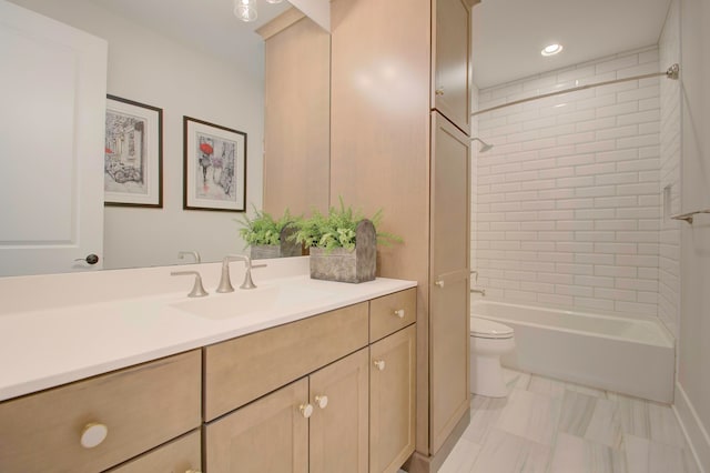 full bathroom with tiled shower / bath, vanity, and toilet