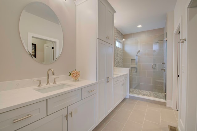 bathroom featuring walk in shower, vanity, and tile patterned flooring