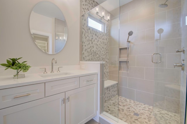 bathroom featuring a shower with door and vanity