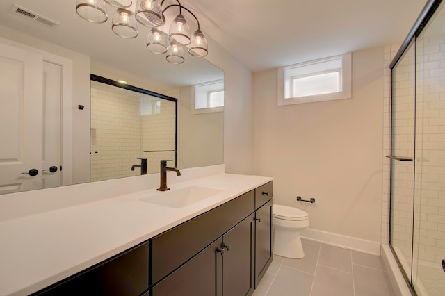 bathroom with vanity, toilet, a shower with door, and tile patterned floors