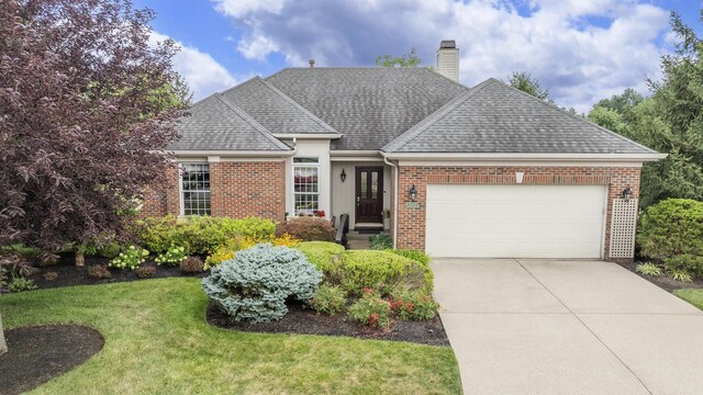 view of front of home with a front lawn and a garage