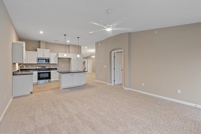 kitchen featuring sink, white cabinetry, a center island, hanging light fixtures, and stainless steel appliances