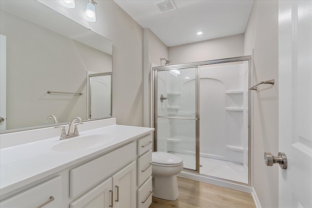 bathroom featuring vanity, hardwood / wood-style floors, toilet, and walk in shower