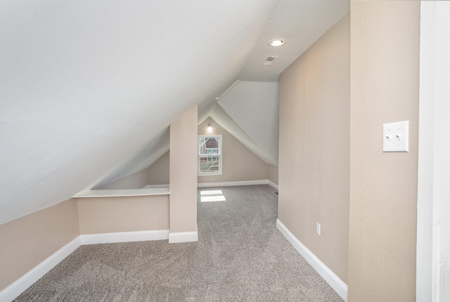 additional living space with carpet flooring and lofted ceiling