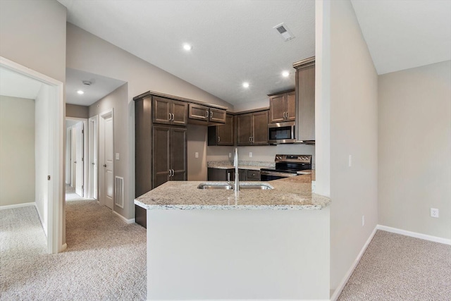 kitchen with lofted ceiling, sink, kitchen peninsula, stainless steel appliances, and light stone countertops