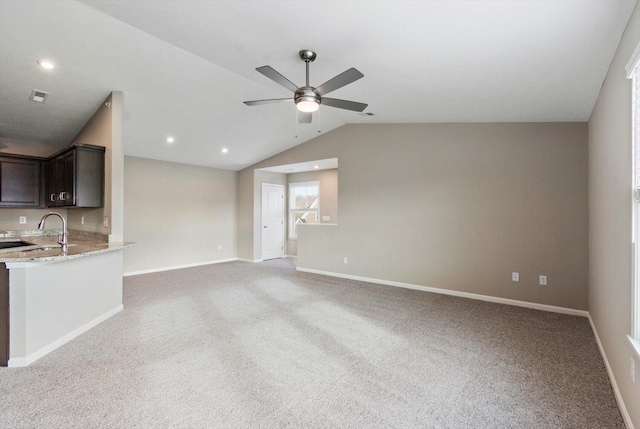 unfurnished living room featuring sink, vaulted ceiling, ceiling fan, and carpet flooring