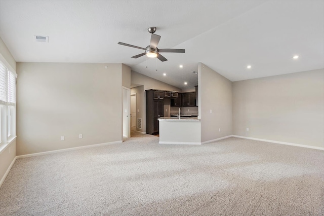 unfurnished living room featuring vaulted ceiling, light colored carpet, and ceiling fan