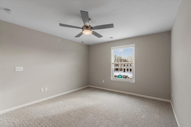 carpeted spare room featuring ceiling fan and a textured ceiling