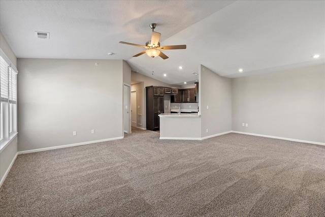 unfurnished living room with vaulted ceiling, ceiling fan, and baseboards