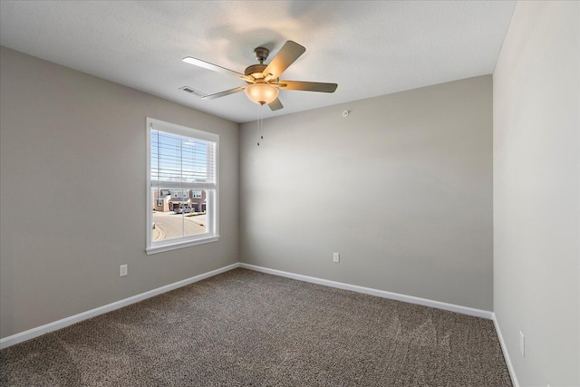 empty room with a textured ceiling, ceiling fan, and carpet