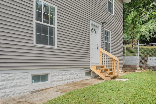 view of exterior entry with a lawn