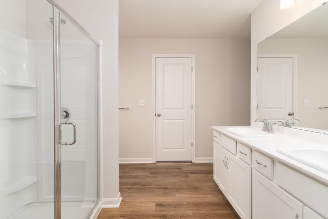 bathroom featuring hardwood / wood-style floors, vanity, and a shower with door