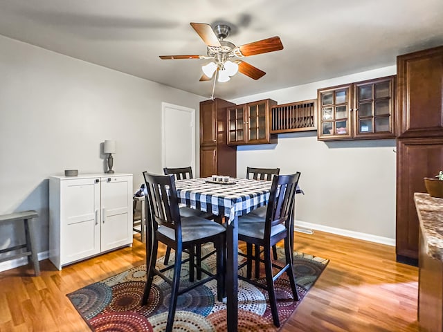 dining room with ceiling fan and light hardwood / wood-style flooring