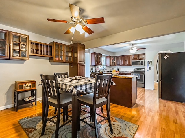 dining area featuring light hardwood / wood-style floors, sink, and ceiling fan