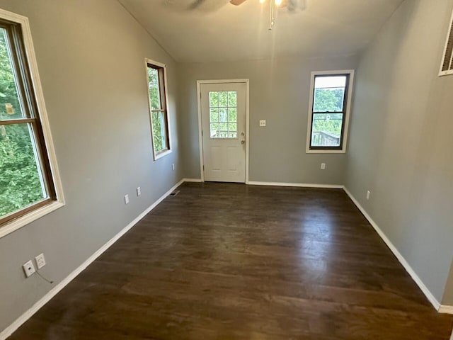 interior space with dark wood-type flooring, lofted ceiling, ceiling fan, and baseboards