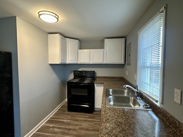 kitchen with dark wood-style flooring, a sink, white cabinetry, black electric range, and dark countertops