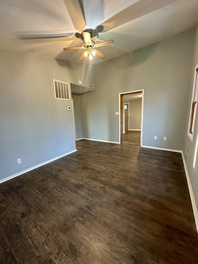 unfurnished room featuring a ceiling fan, baseboards, visible vents, and dark wood-style flooring