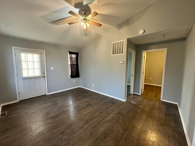 spare room featuring dark wood-type flooring, visible vents, ceiling fan, and baseboards