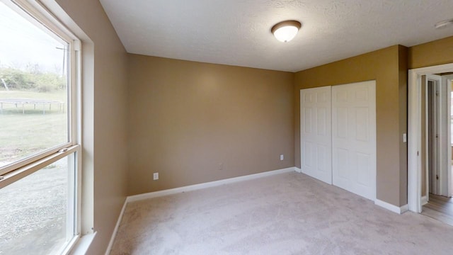 304 Brentwood Dr, Dry Ridge, KY 41035 - unfurnished bedroom with baseboards, a closet, light colored carpet, and a textured ceiling