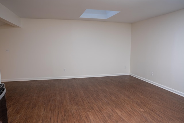 unfurnished room with dark hardwood / wood-style flooring and a skylight