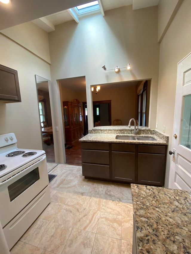 kitchen featuring electric range, light tile patterned floors, sink, and dark brown cabinetry